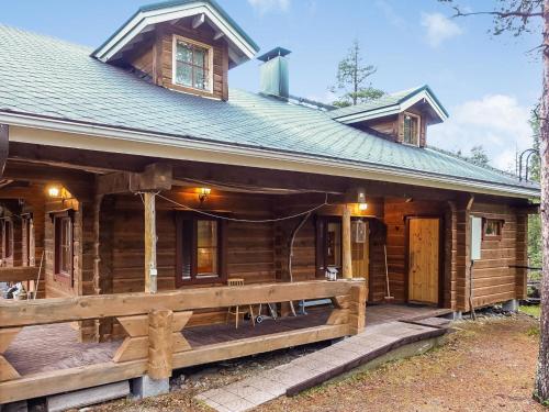 a log cabin with a porch and a house at Holiday Home Valkonen pohjonen b by Interhome in Levi