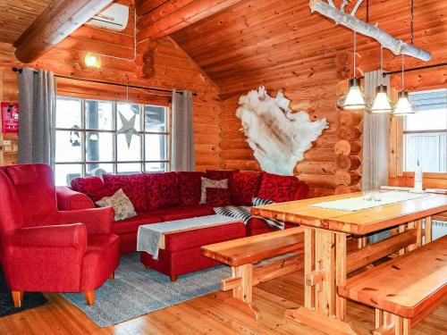 a living room with a red couch and a table at Holiday Home Tikkatupa by Interhome in Levi