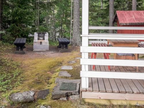 dois bancos sentados ao lado de uma casa com um grelhador em Holiday Home Hiekkasaari by Interhome em Juhanala