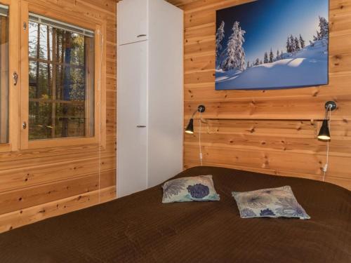 ein Schlafzimmer mit einem Bett und einem Fernseher an der Wand in der Unterkunft Holiday Home Aurinko-saga by Interhome in Ylläsjärvi