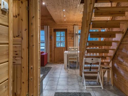 eine Treppe in einem Blockhaus mit einem Tisch und Stühlen in der Unterkunft Holiday Home Aurinko-saga by Interhome in Ylläsjärvi