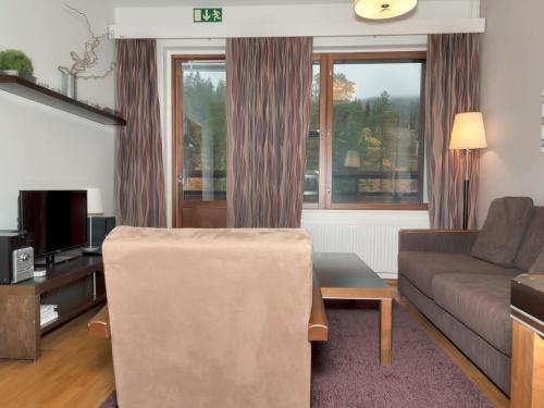 a living room with a couch and a table at Holiday Home Ylläs chalets 3508 by Interhome in Ylläs