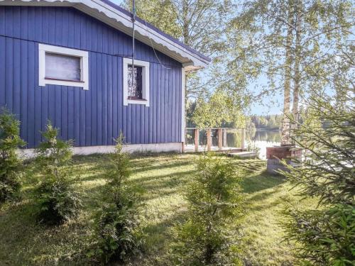 JuhanalaにあるHoliday Home Rantala by Interhomeの庭の木々のある青い家