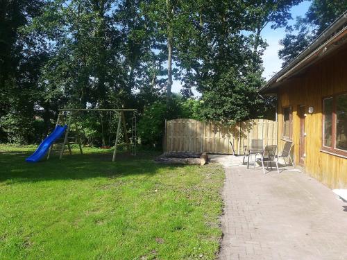 einen Hof mit einem Spielplatz mit Stühlen und einer Schaukel in der Unterkunft Apartment Landblick-1 by Interhome in Süderneuland Zwei