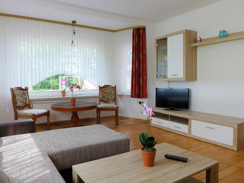 un salon avec une télévision et une table dans l'établissement Apartment Landblick-1 by Interhome, à Süderneuland Zwei