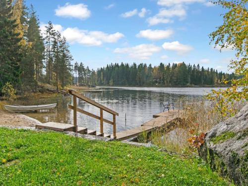 a dock on a lake with a boat in the water at Holiday Home Pihlajakumpu by Interhome in Petäjävesi