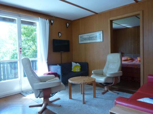 ein Wohnzimmer mit einem Sofa, 2 Stühlen und einem Tisch in der Unterkunft Apartment Casa Mira by Interhome in Engelberg