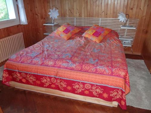 ein Schlafzimmer mit einem großen Bett mit einer roten Bettdecke in der Unterkunft Apartment Casa Mira by Interhome in Engelberg