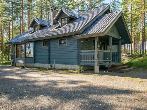 una pequeña casa azul con techo de gambrel en Holiday Home Kuvalanranta by Interhome en Mouhu
