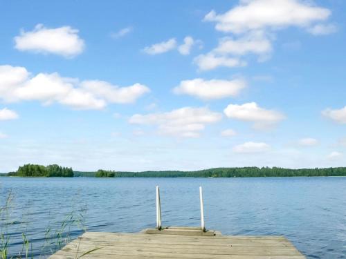 un molo su un lago con cielo azzurro e nuvole di Holiday Home Beach 2 - 5664 by Interhome a Vääksy