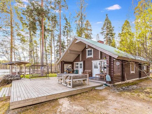 a log cabin with a deck and a picnic table at Holiday Home Beach 2 - 5664 by Interhome in Vääksy