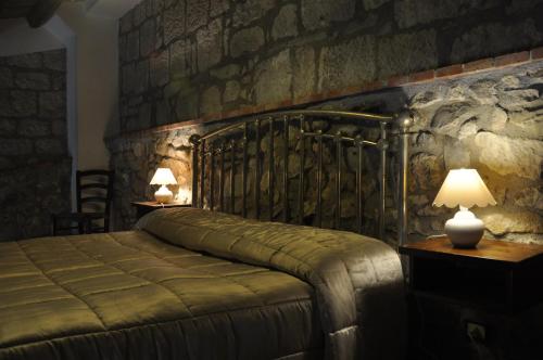a bedroom with a bed and two lamps on tables at Case Eleutheria in Petralia Soprana