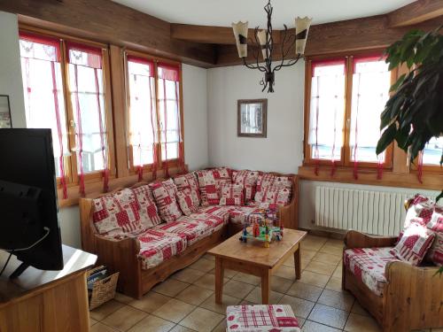ein Wohnzimmer mit Sofas und einem Tisch in der Unterkunft La Source Du Pré Masset in Métabief