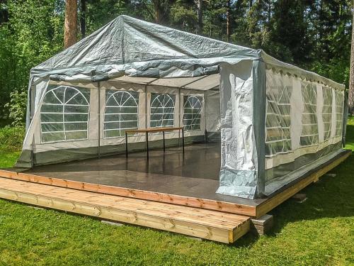 a greenhouse with a wooden deck in the grass at Holiday Home Päätalo by Interhome in Vääksy