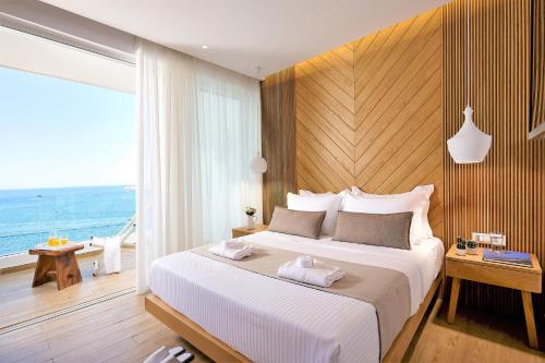 a bedroom with a large bed with a view of the ocean at Citrus Exclusive in Agios Nikolaos