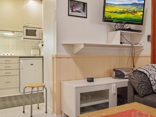 Elle comprend un salon avec un bureau et une télévision murale. dans l'établissement Holiday Home Yllästar 1 as 202 by Interhome, à Äkäslompolo