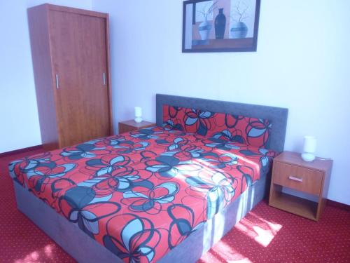 a bedroom with a bed with a red and blue bedspread at Apartment Karlovy Vary in Karlovy Vary