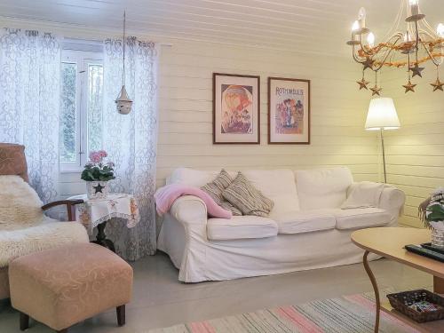 uma sala de estar com um sofá branco e uma cadeira em Holiday Home Inninniemi by Interhome em Pyhäsalmi