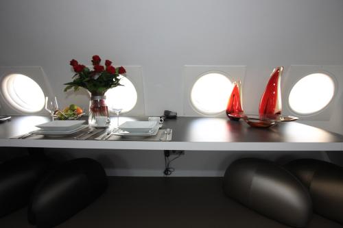 a table with plates and a vase of flowers on it at Vliegtuigsuite Teuge in Teuge