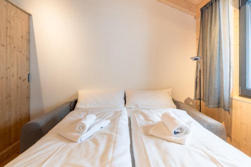 a bed with two white towels on top of it at Chalet Allgäublick in Sonthofen