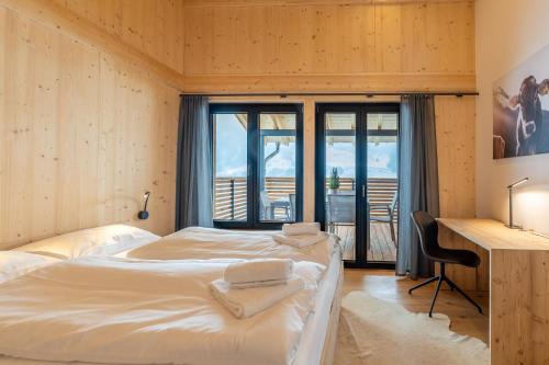 a bedroom with two beds and a desk and a window at Chalet Allgäublick in Sonthofen