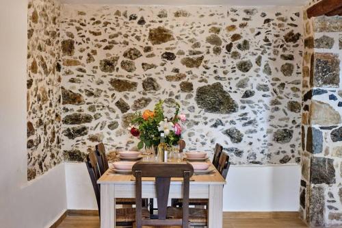 a dining room with a table with flowers on it at Maria's cozy stonehouse in Kerames