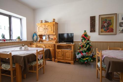 a living room with a christmas tree and two tables at Casa per ferie BeatoRosaz in Cesana Torinese