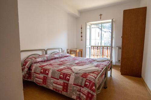 a bedroom with a bed and a cross on the wall at Casa per ferie BeatoRosaz in Cesana Torinese