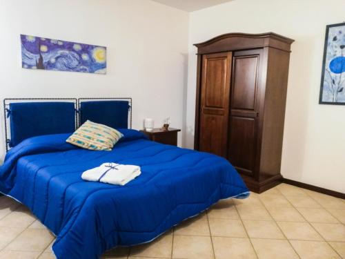 Terre Di Gratia في Camporeale: غرفة نوم بسرير ازرق وخزانة خشبية