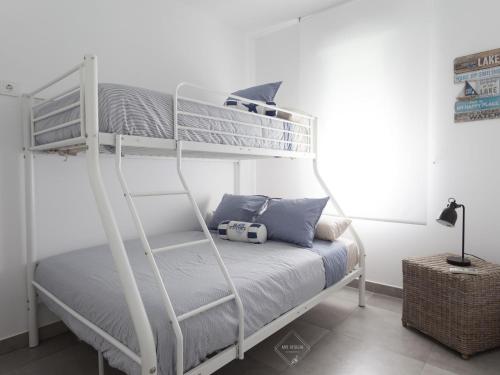 a bedroom with a bunk bed with blue pillows at La Fontanilla Place in Conil de la Frontera