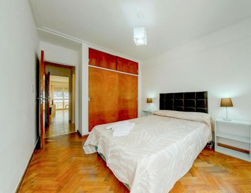 a bedroom with a large bed and a wooden floor at Departamento Parque España in Rosario
