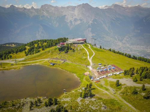 an aerial view of a resort on a hill next to a lake at Chalet des Alpes NATURE & MOUNTAIN by Alpvision Résidences in Prarion