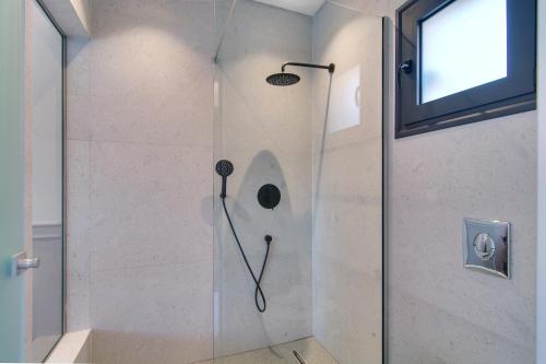 a shower in a bathroom with a glass door at Charisma Boutique Hotel in Parga