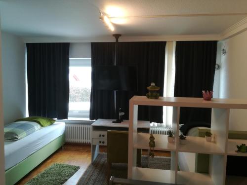 a bedroom with a bed and a desk and a window at Apartment Froschkönig in Gladenbach