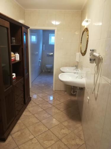 a bathroom with two sinks and a toilet and a mirror at Apartment Froschkönig in Gladenbach