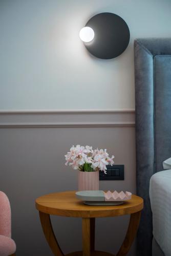 a table with a vase of pink flowers on it at Charisma Boutique Hotel in Parga