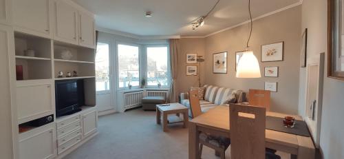 sala de estar con mesa de comedor y TV en Appartment - Sylter Traumzeit, en Westerland