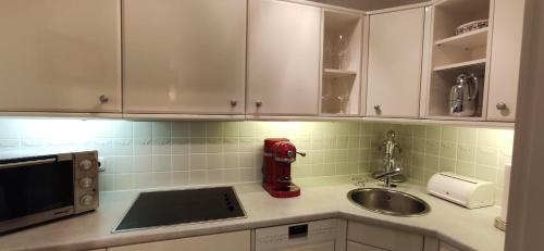 una cocina con fregadero y un aparato rojo en una encimera en Appartment - Sylter Traumzeit, en Westerland