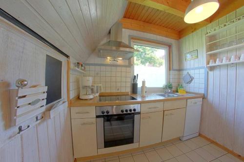 a small kitchen with a stove and a sink at SR VS1 Haus Ellie in Dorum-Neufeld