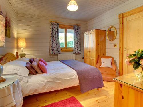 SwarlandにあるLime Tree Lodgeのベッドルーム1室(ベッド1台、椅子付)