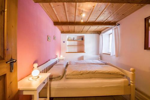 - une chambre avec un lit et un plafond en bois dans l'établissement Ferienwohnung Filser, à Unterammergau