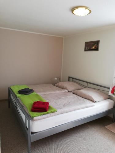 a bedroom with a bed with a green blanket on it at Ferienhaus Waldglück in Tanne