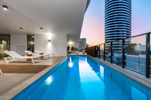 een zwembad met uitzicht op een gebouw bij Koko Broadbeach in Gold Coast