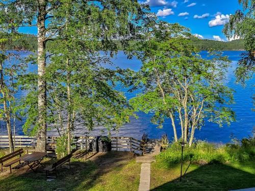 a park with benches and a view of a lake at Holiday Home Kesäranta by Interhome in Simanala