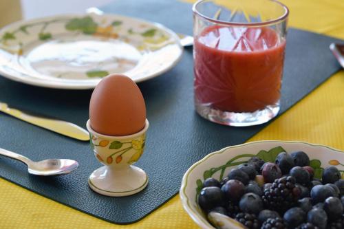 un tavolo con un uovo, un piatto di uva e una bevanda di Harry's Home Tiel Bed & Breakfast a Tiel