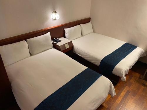 two beds in a hotel room with a box between them at Gene Long Haiy Att Hotel in Chiayi City