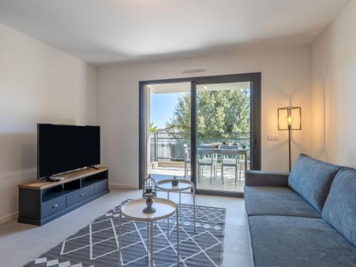 a living room with a couch and a tv at Apartment St Joseph-1 by Interhome in Porto-Vecchio