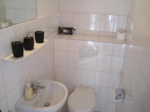 a white bathroom with a toilet and a sink at Central Wohnen in Wilhelmshaven