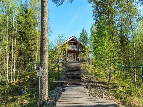 une maison dans les bois avec des escaliers menant à celle-ci dans l'établissement Holiday Home Väinämöinen by Interhome, à Tohmajärvi