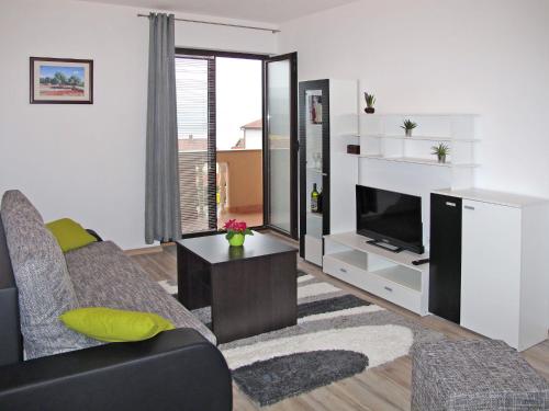 salon z kanapą i telewizorem w obiekcie Apartment Rosić - KRK217 by Interhome w mieście Kornić